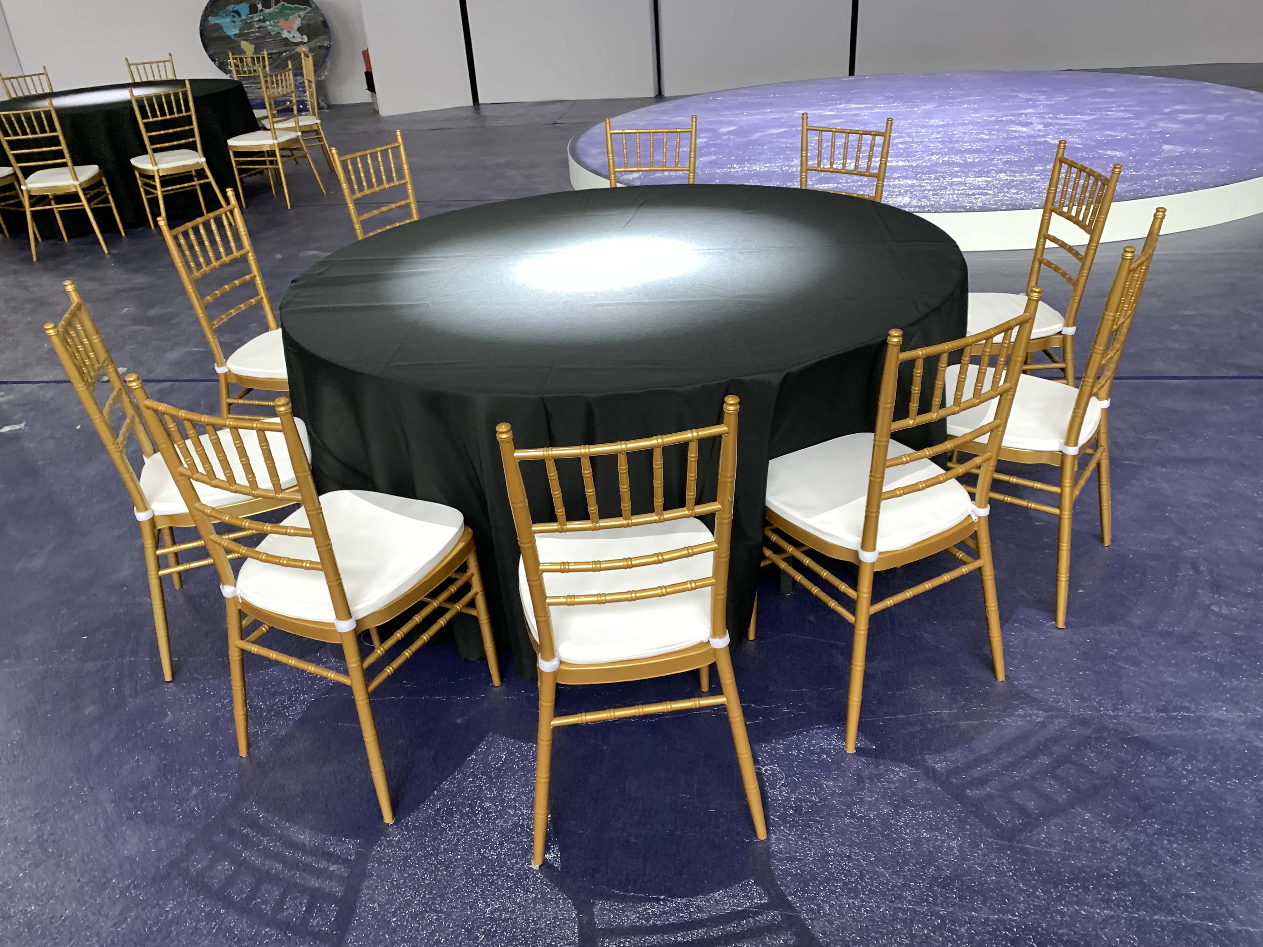 Shanghai banquet chair rental — gold Chiavari chairs with black tablecloth round tables on deep purple floor